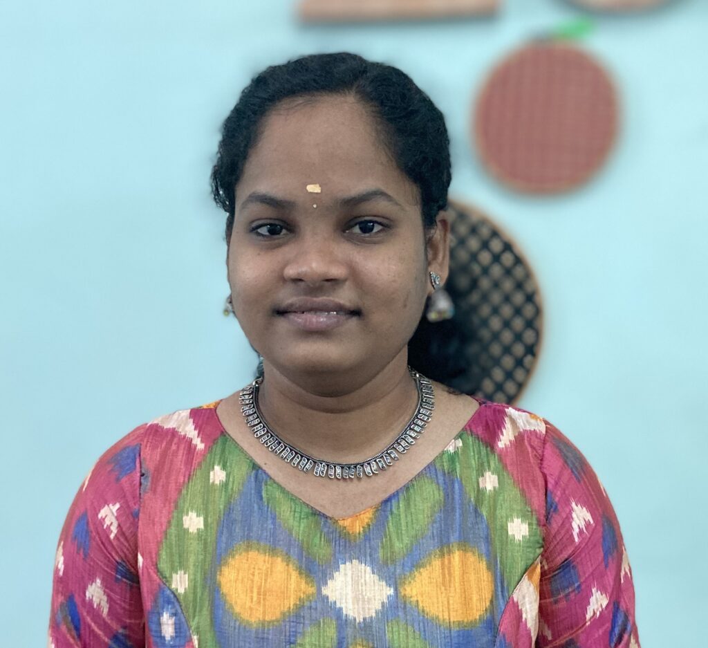 A student smiling while holding a completed garment at Design Loft Sewing School