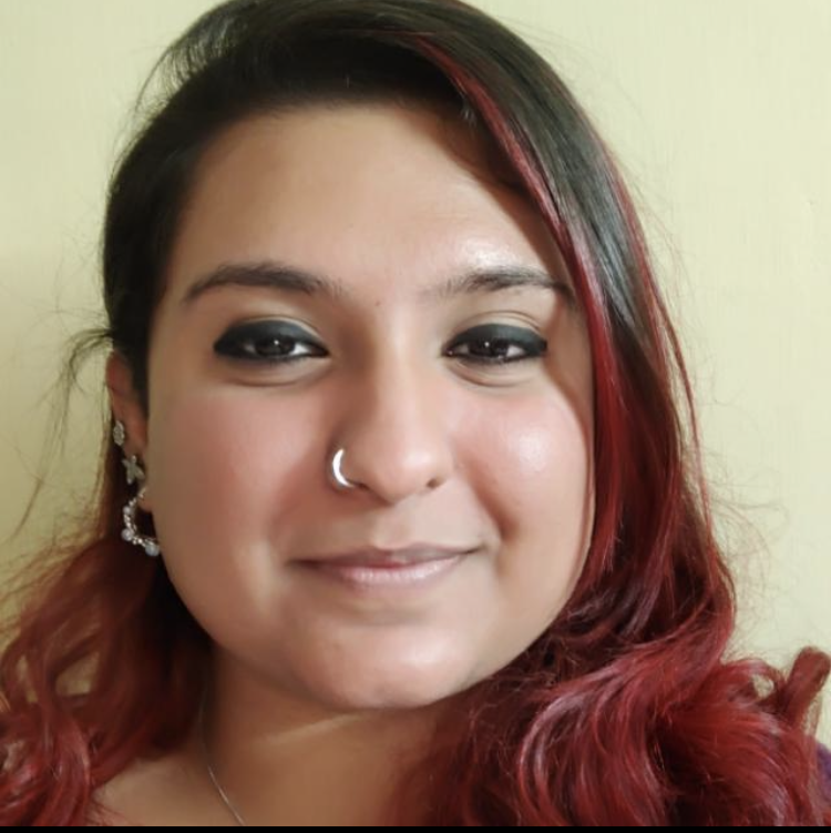 A student smiling while holding a completed garment at Design Loft Sewing School