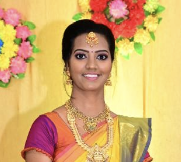 A student smiling while holding a completed garment at Design Loft Sewing School