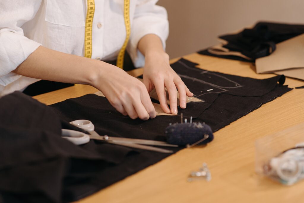 A student marking patterns on a piece of fabric at Design Loft Sewing School